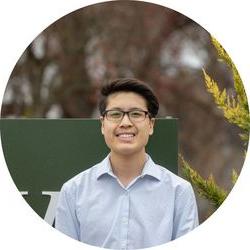 Joseph wearing a button-down and standing in front of the WWU sign.